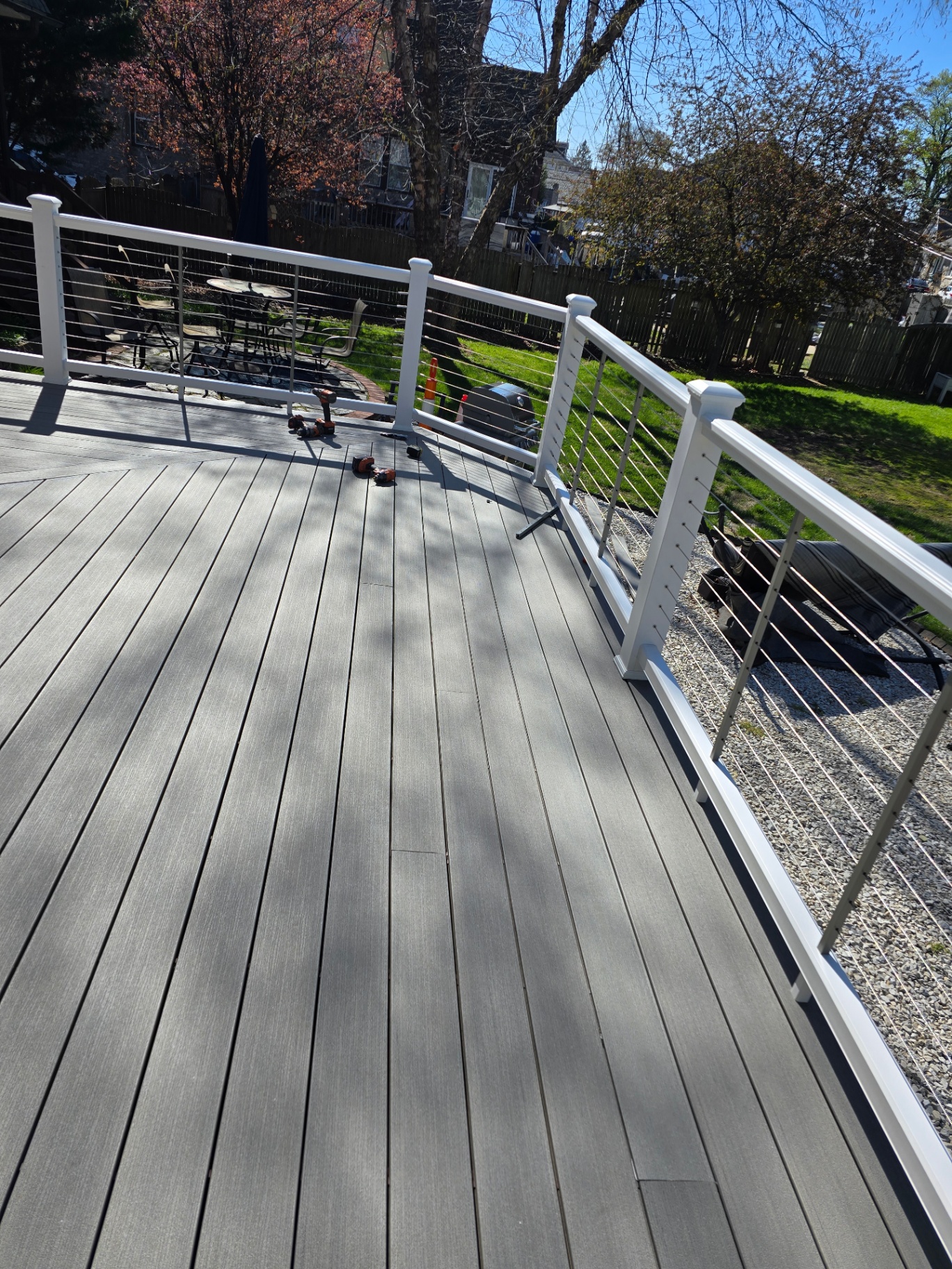 Curved gray composite deck with stainless cable railing