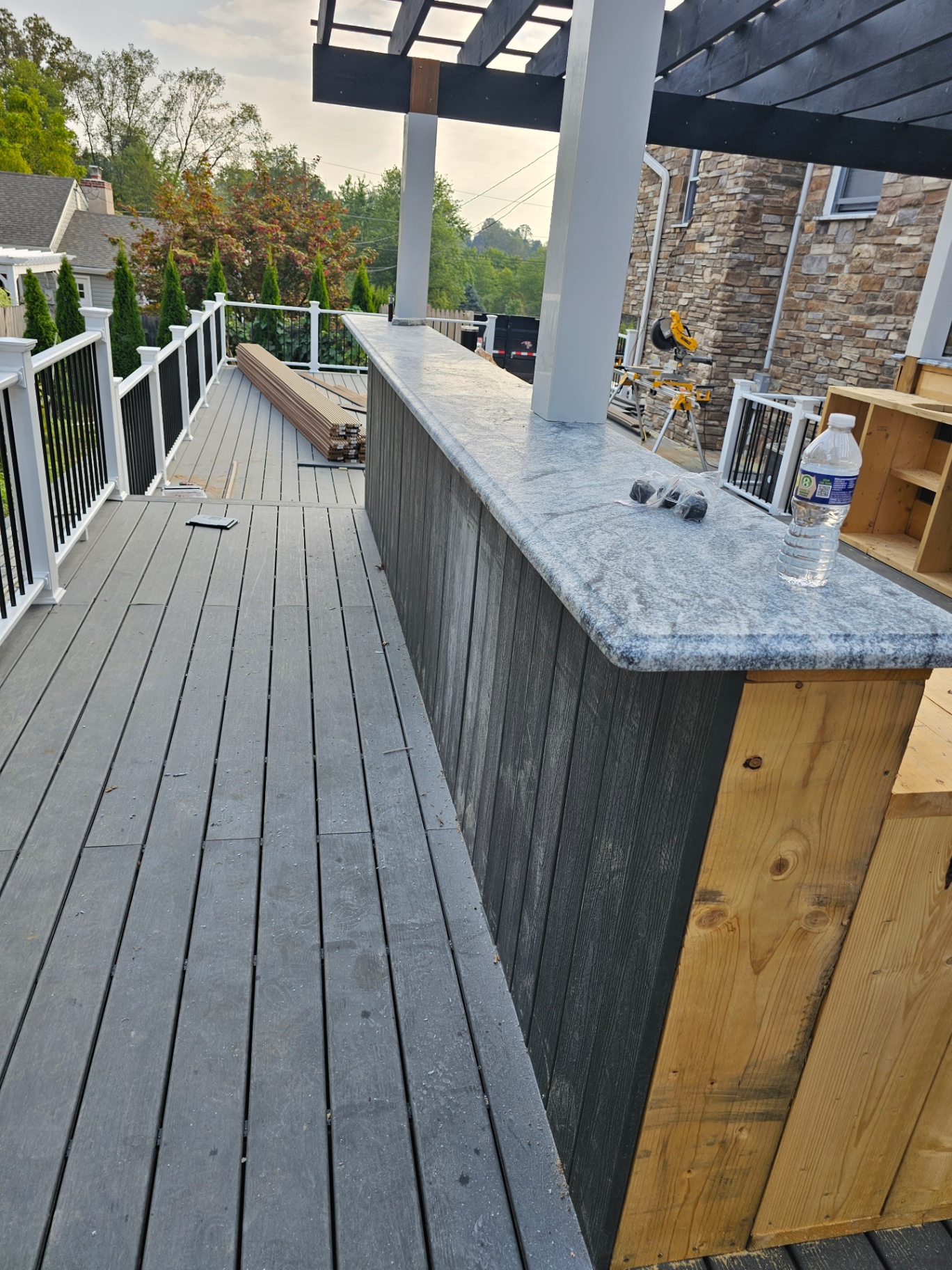 Outdoor bar with granite top under a black pergola