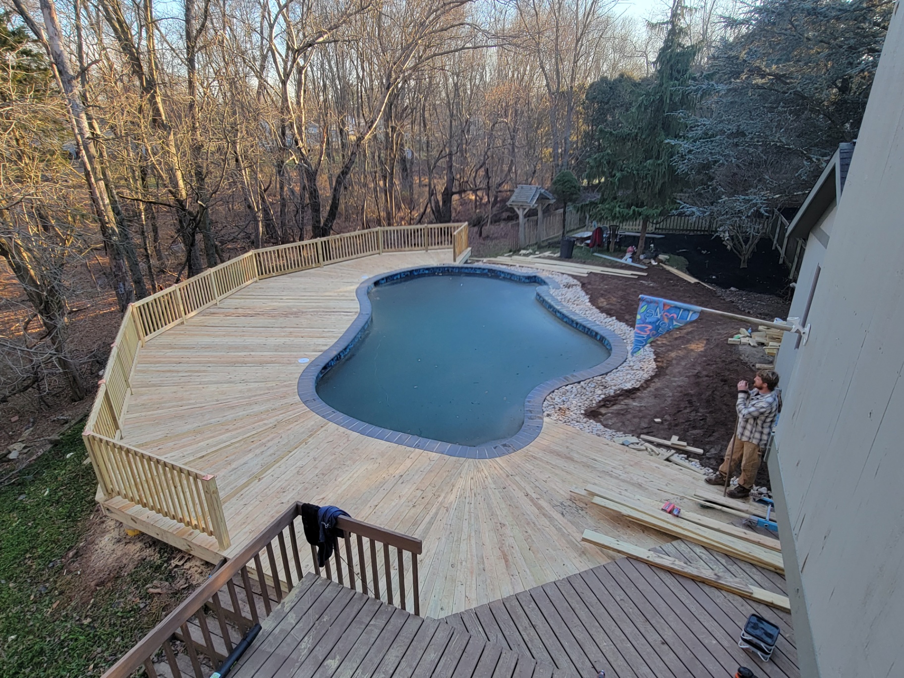 Finished pool deck wrapping a freeform in-ground pool