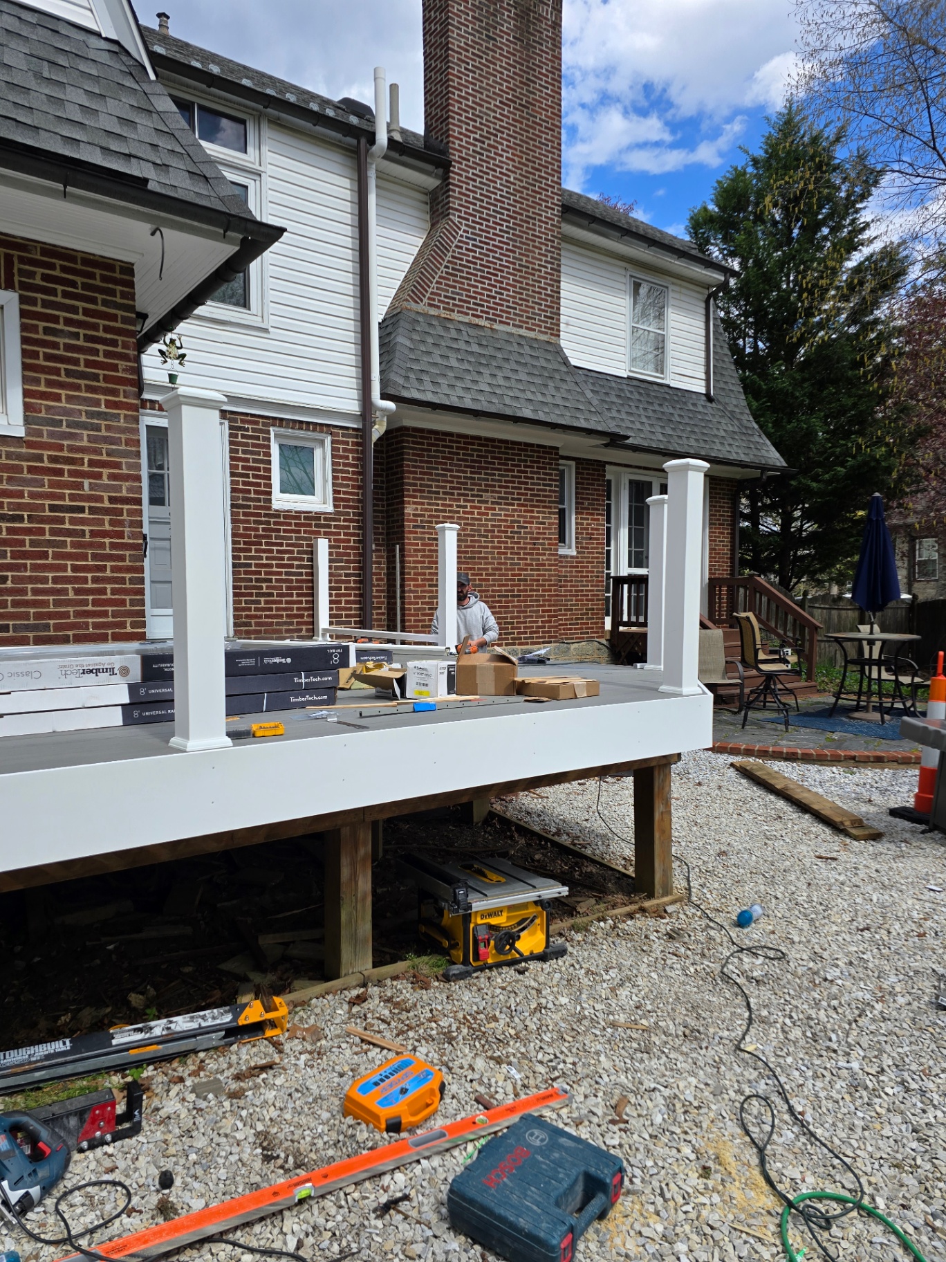 Composite deck build in progress with white fascia and posts