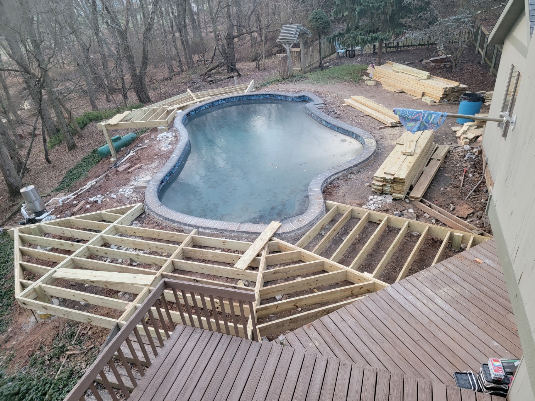 Pool deck framing under construction around in-ground pool