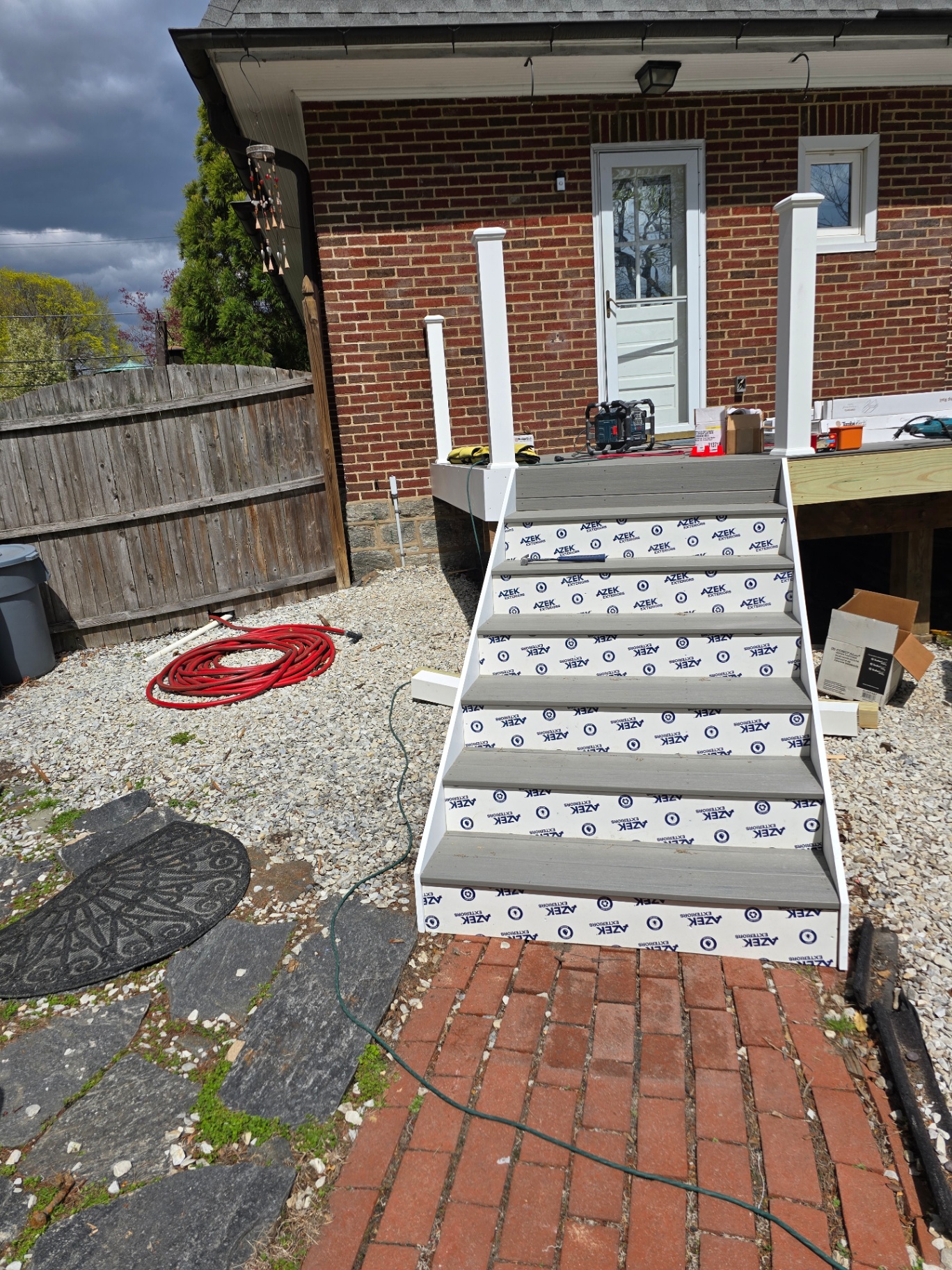 AZEK composite staircase with white posts to brick home