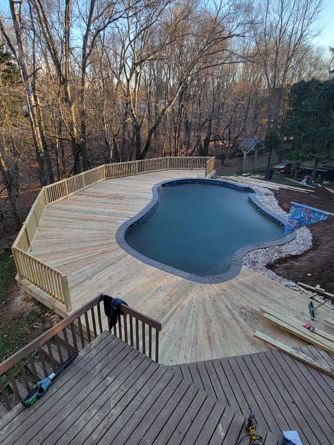 Pool deck with new wood railings overlooking woods