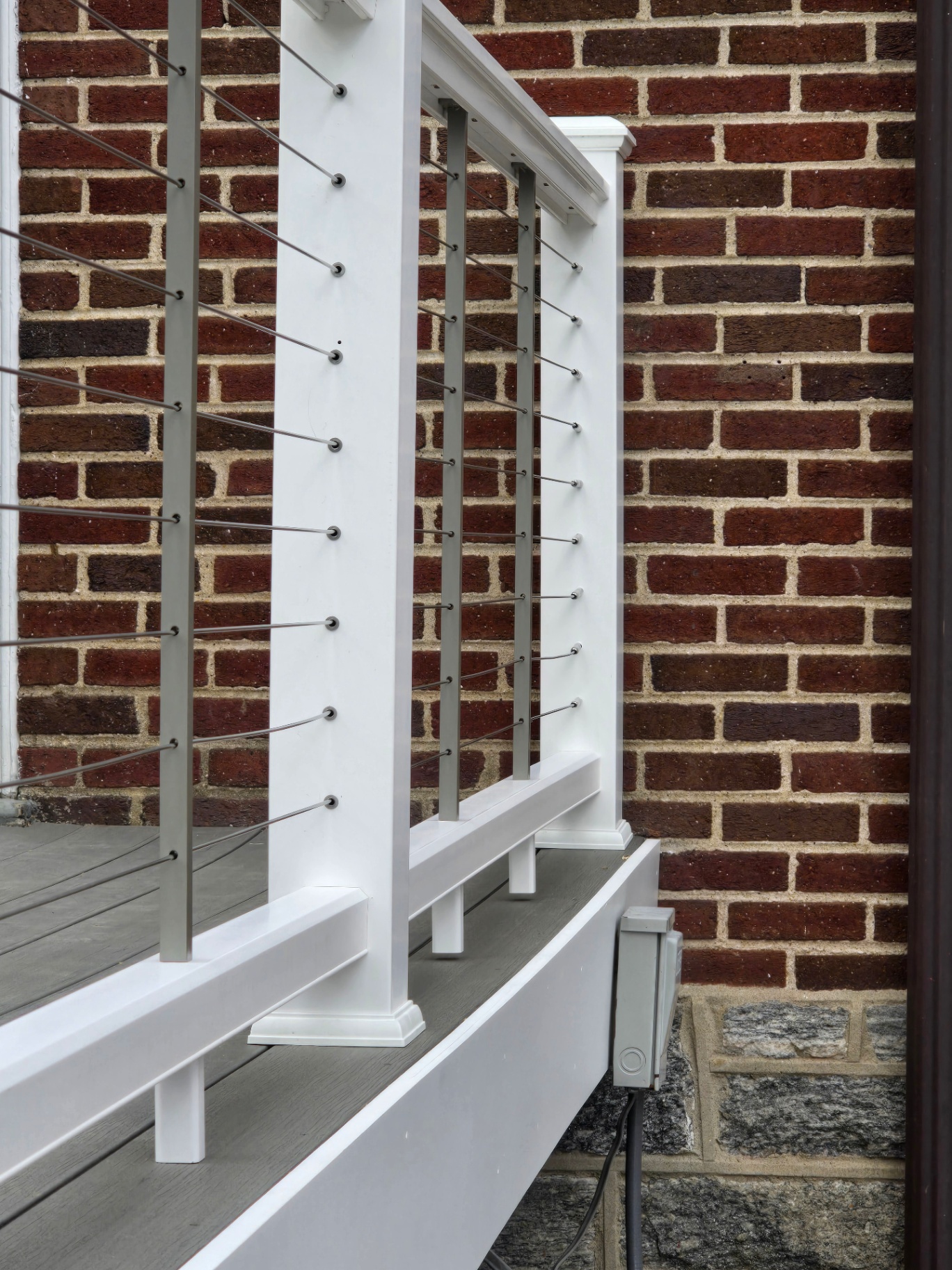 Cable railing detail with stainless cables and white posts